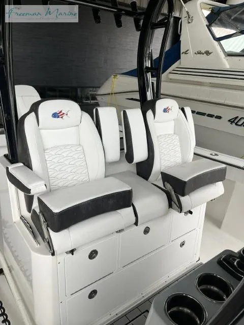 Slide: The Image of 2022 Crevalle 33 CSF boat interior with luxurious white seating and storage compartments. - 14