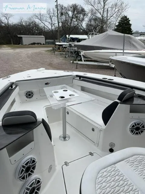 Slide: The Image of 2022 Crevalle 33 CSF boat interior with seating and table, parked outdoors. - 28