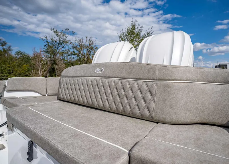 Slide: The Image of 2025 Sea Hunt Ultra 275 SE boat seating with quilted upholstery under a blue sky. - 10