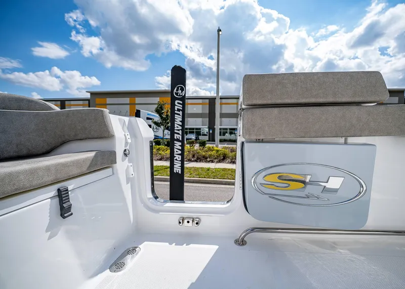 Slide: The Image of 2025 Sea Hunt Ultra 275 SE boat interior with seating and logo, under a partly cloudy sky. - 13