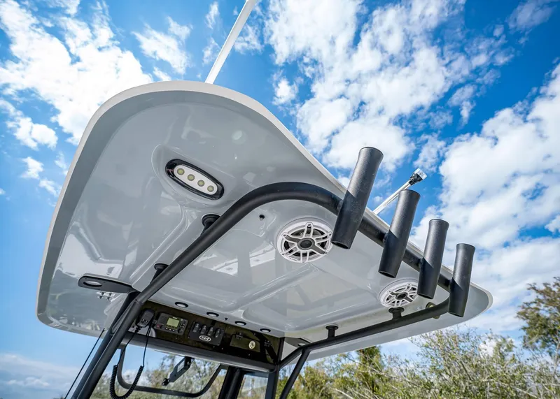 Slide: The Image of Sea Hunt Ultra 275 SE 2025 boat T-top with rod holders against blue sky. - 17