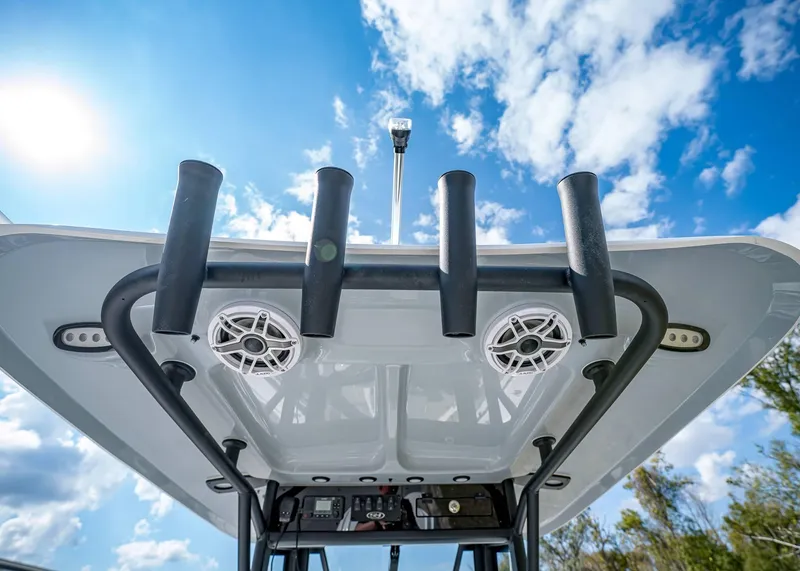 Slide: The Image of 2025 Sea Hunt Ultra 275 SE boat roof with rod holders and speakers under blue sky. - 18