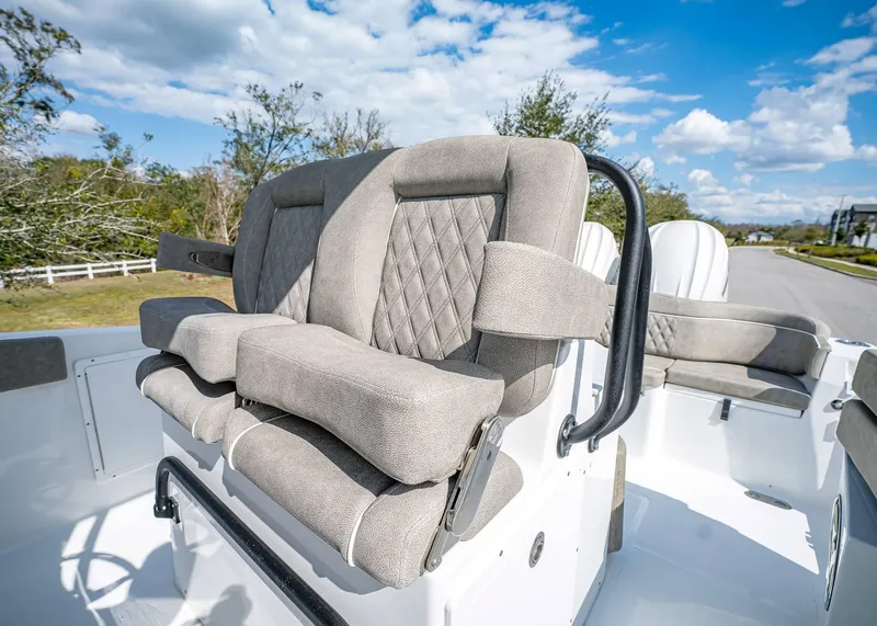 Slide: The Image of 2025 Sea Hunt Ultra 275 SE boat seating with plush, diamond-stitched upholstery under a clear sky. - 24