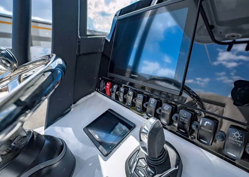 Slide: The Image of Control panel of 2025 Sea Hunt Ultra 275 SE boat with Garmin display and switches. - 30