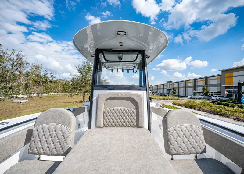 Slide: The Image of 2025 Sea Hunt Ultra 275 SE boat interior with plush seating under a clear blue sky. - 39