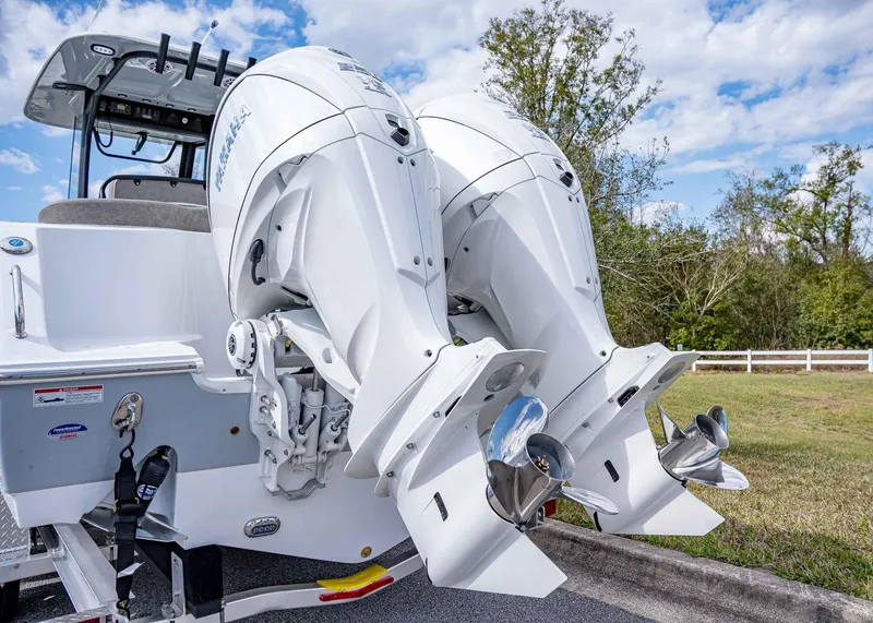 Slide: The Image of 2025 Sea Hunt Ultra 275 SE boat with dual outboard engines, parked outdoors. - 4
