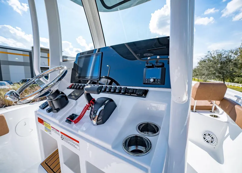 Slide: The Image of 2025 Sea Hunt Ultra 235 SE boat dashboard with steering wheel and controls. - 20