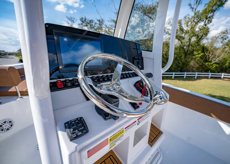 Slide: The Image of 2025 Sea Hunt Ultra 235 SE boat dashboard with steering wheel and control panel. - 24