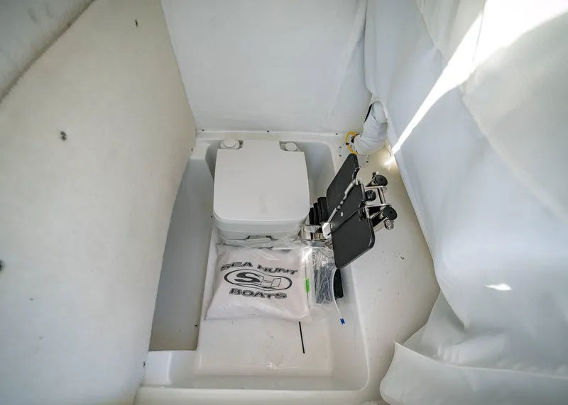 Slide: The Image of 2025 Sea Hunt Ultra 235 SE boat interior with storage compartment and equipment. - 28