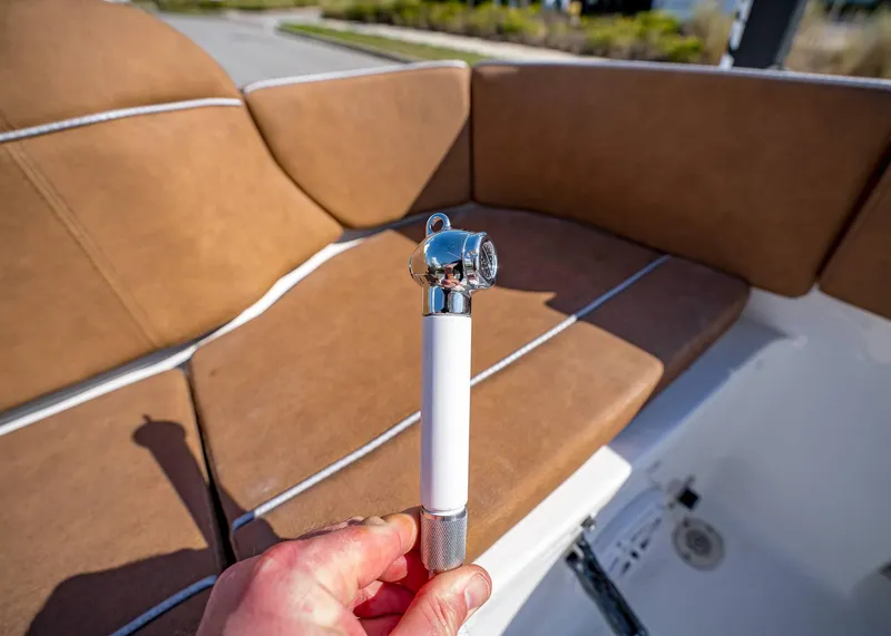 Slide: The Image of Hand holding a boat accessory on Sea Hunt Ultra 235 SE, 2025 model, with brown seating. - 9