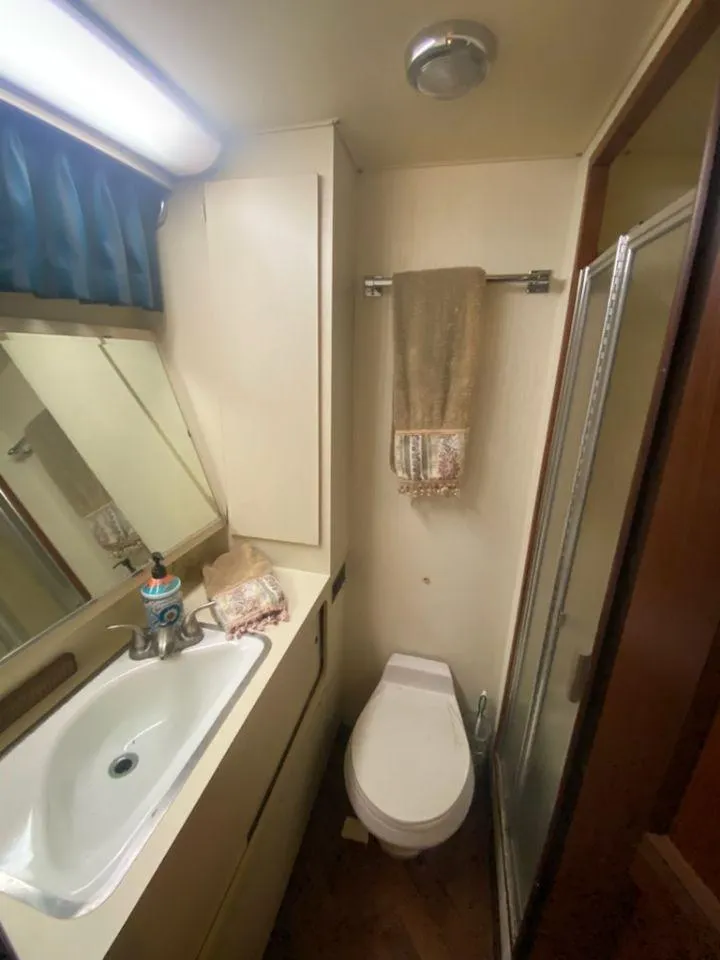 Slide: The Image of 1987 Hatteras 40 Double Cabin bathroom with sink, toilet, and shower. - 13