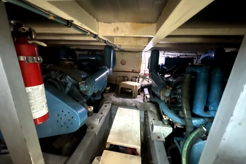 Slide: The Image of Engine room of 1987 Hatteras 40 Double Cabin with visible fire extinguisher and machinery. - 16