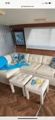 Slide: The Image of 1987 Hatteras 40 Double Cabin interior with white sofa, blue accents, and wooden flooring. - 5