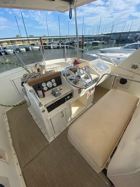 Slide: The Image of 1987 Hatteras 40 Double Cabin helm with beige seating, docked at marina. - 8