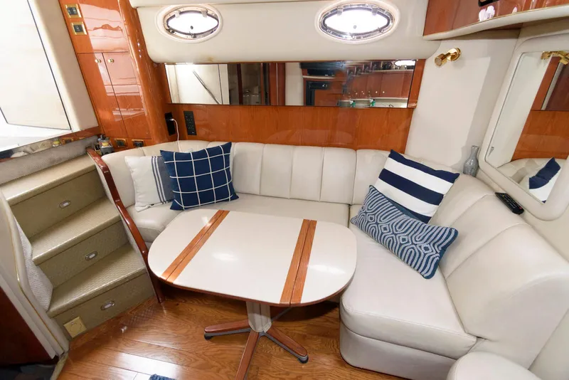 Slide: The Image of Interior of 1998 Sea Ray 450 Sundancer with white leather seating and decorative pillows. - 10