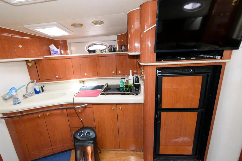 Slide: The Image of Interior of 1998 Sea Ray 450 Sundancer yacht kitchen with wood cabinetry and appliances. - 11