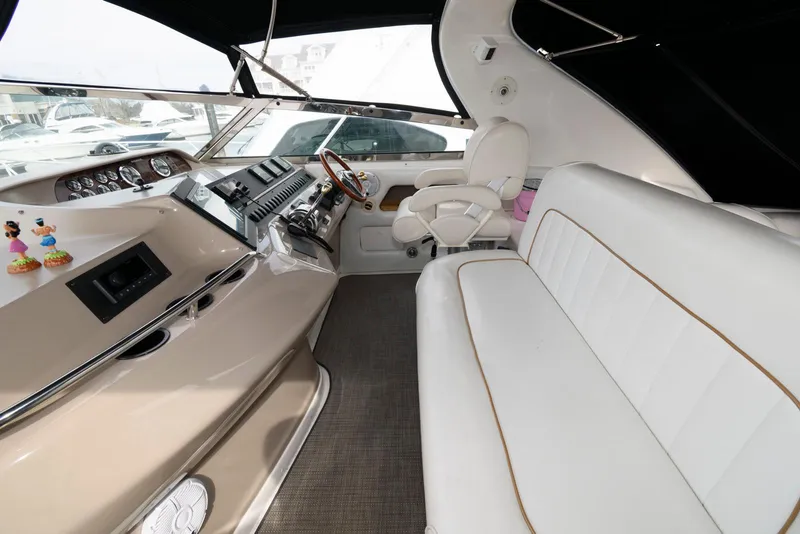 Slide: The Image of 1998 Sea Ray 450 Sundancer cockpit with white seating and modern controls. - 3