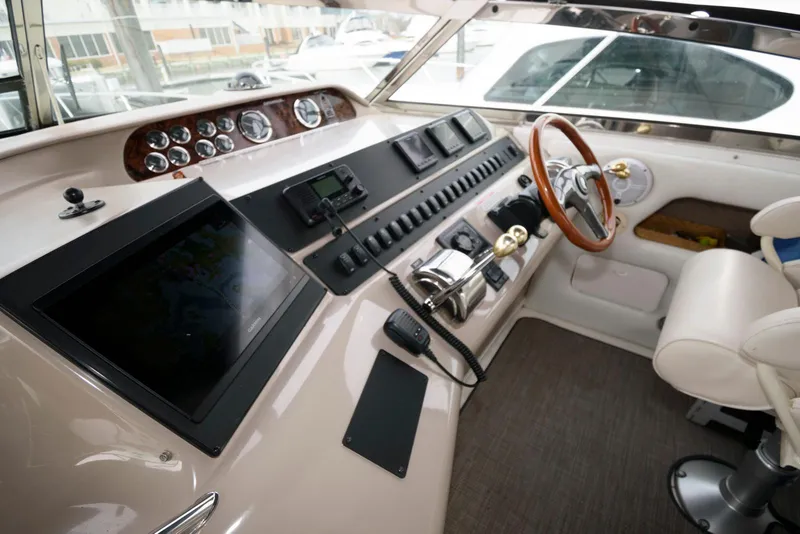 Slide: The Image of 1998 Sea Ray 450 Sundancer helm with modern controls and wooden steering wheel. - 4