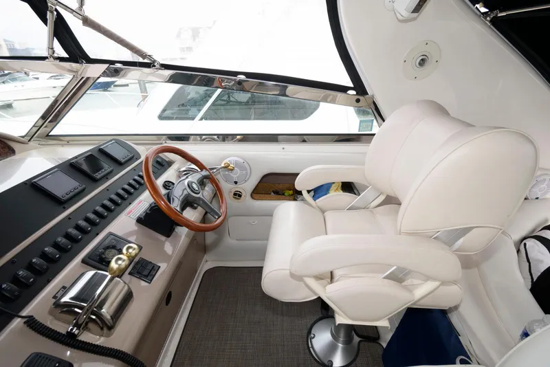 Slide: The Image of 1998 Sea Ray 450 Sundancer helm with white captain's chair and wooden steering wheel. - 5
