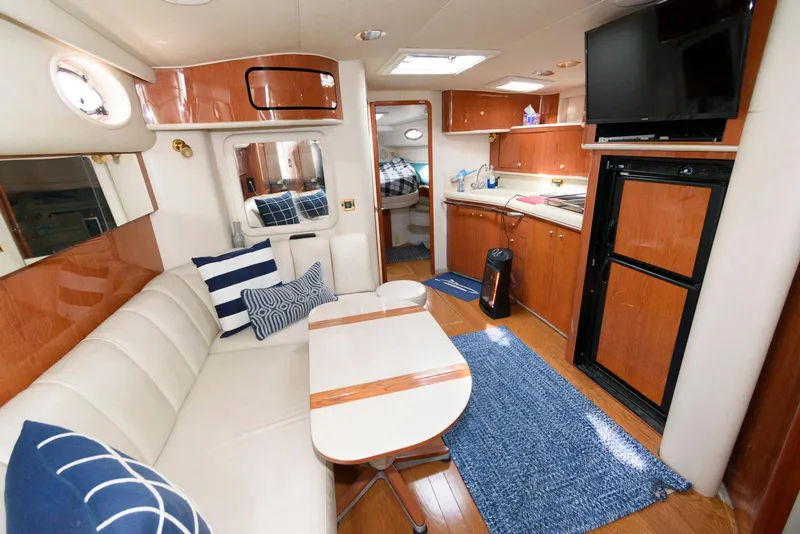 Slide: The Image of Interior of 1998 Sea Ray 450 Sundancer yacht with modern furnishings and kitchen area. - 9