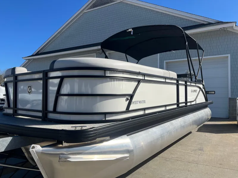 Slide: The Image of 2025 Godfrey Sweetwater Entertainment pontoon boat parked near a garage. - 2