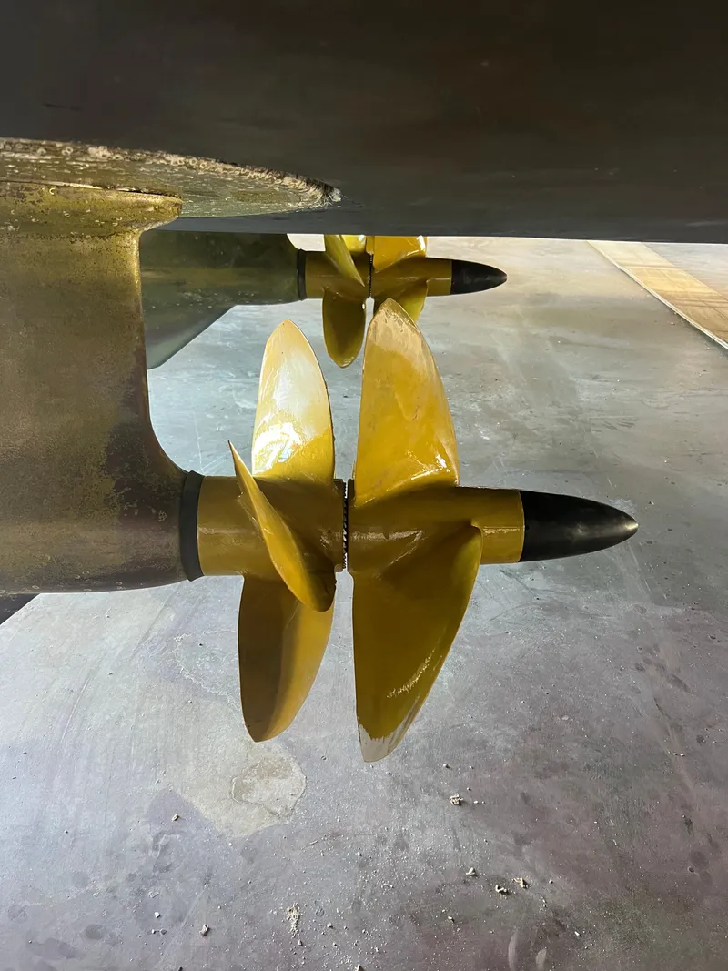 Slide: The Image of Yellow propellers of a 2008 Ovation 52 boat in a dry dock setting. - 10