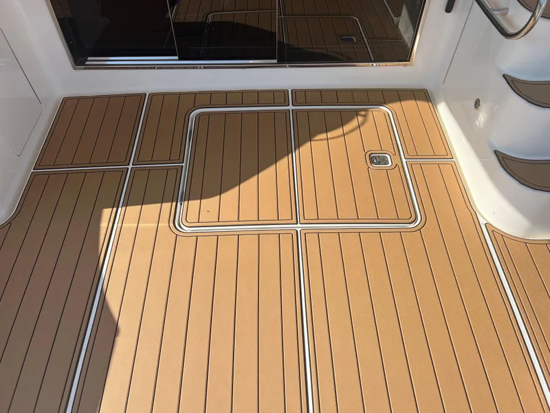 Slide: The Image of Ovation 52 yacht deck, 2008 model, featuring teak-style flooring and sleek design. - 12