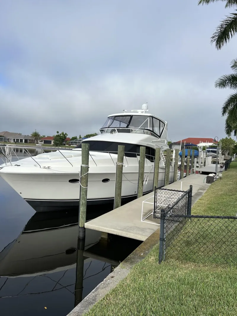 Slide: The Image of 2008 Ovation 52 yacht docked at a marina, surrounded by calm water and lush greenery. - 3