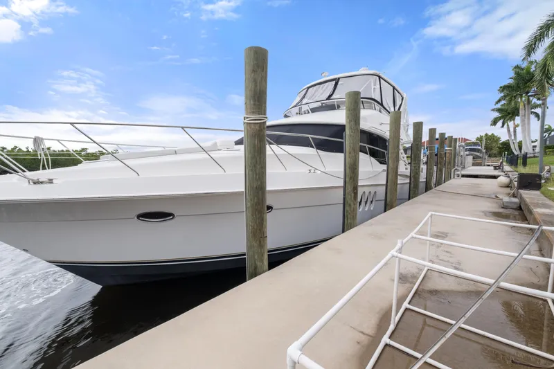 Slide: The Image of Luxury Ovation 52 yacht docked at marina, 2008 model, under clear blue sky. - 4