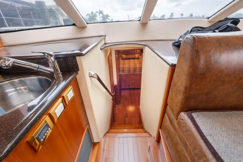 Slide: The Image of Interior of 2008 Ovation 52 yacht, featuring a sleek kitchen and wooden flooring. - 48