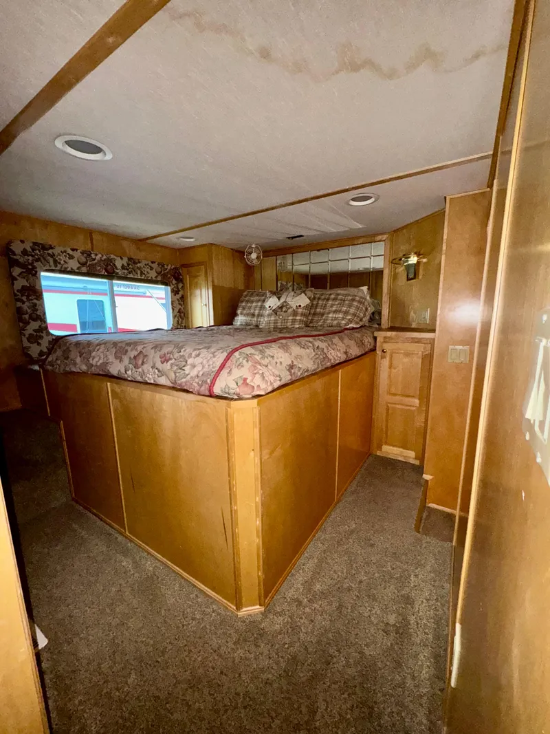 Slide: The Image of Cozy bedroom in 2000 Fantasy Escape From LA RV with wood paneling and carpet flooring. - 11
