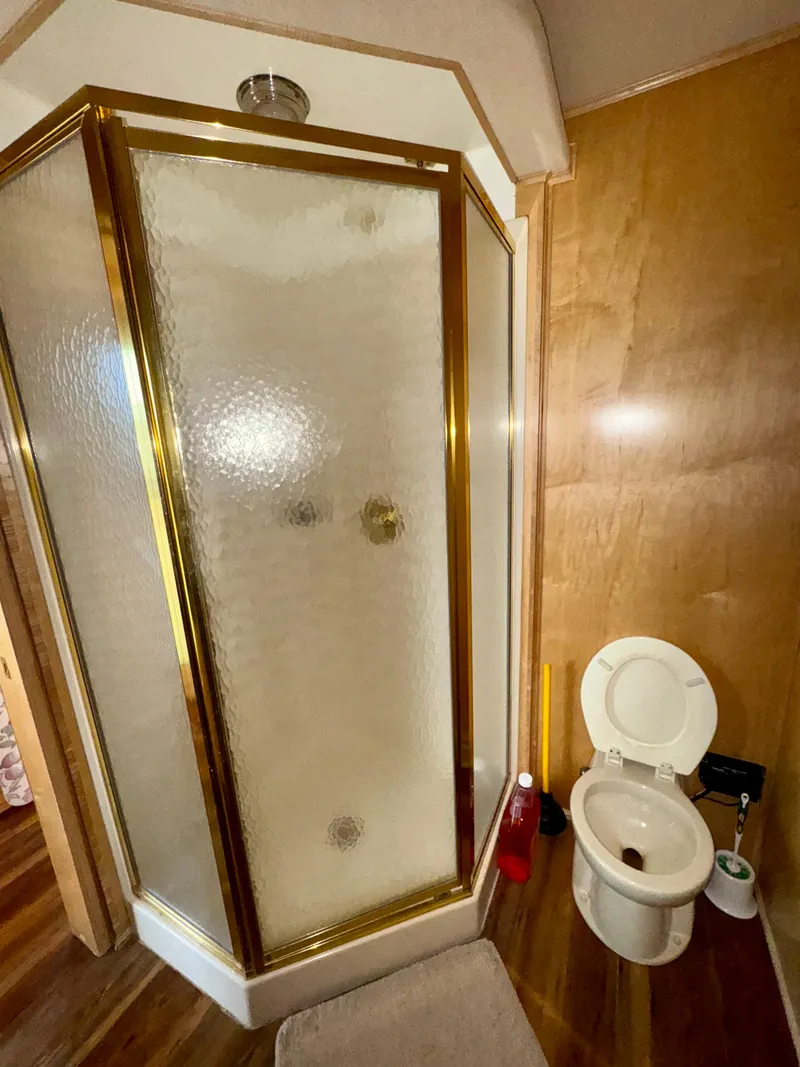 Slide: The Image of Compact bathroom with glass shower and toilet, featuring wood paneling. Fantasy Escape From LA 2000. - 12