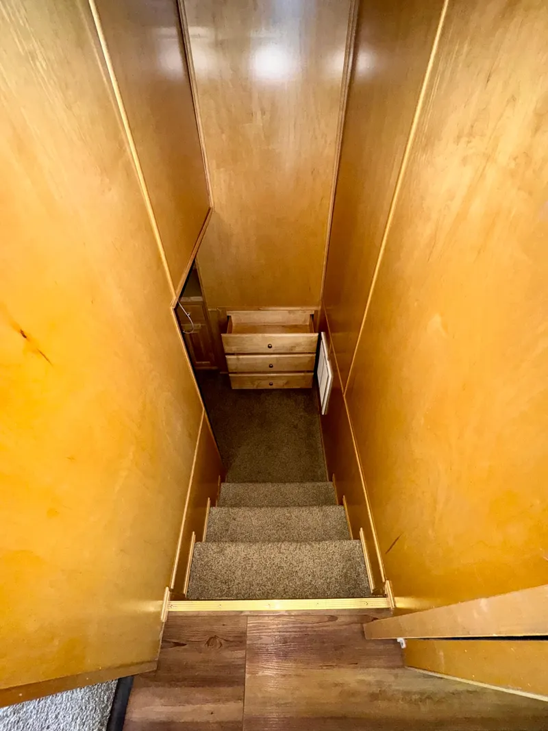 Slide: The Image of Narrow wooden staircase with carpeted steps, leading to a small landing with drawers. - 13