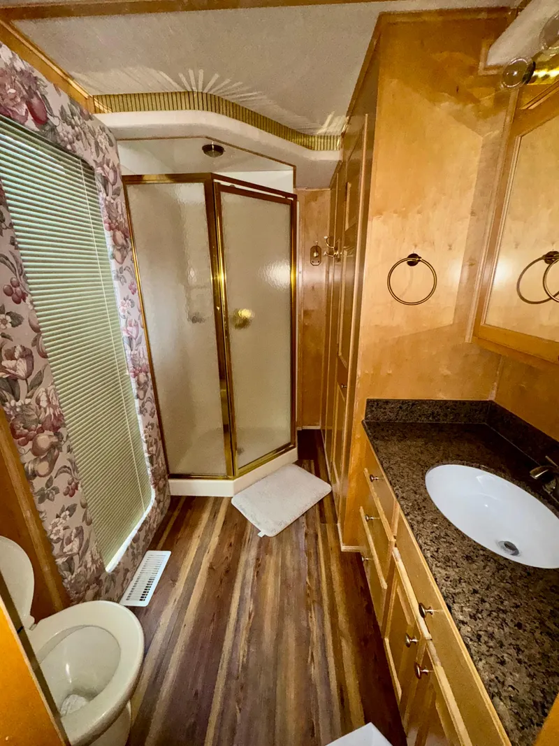 Slide: The Image of Luxurious RV bathroom with wood accents, granite countertop, and glass shower. Fantasy Escape From LA 2000 model. - 17