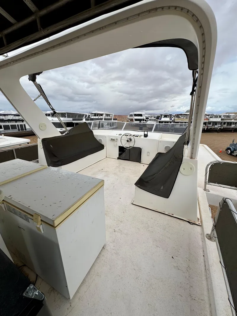 Slide: The Image of Boat deck of 2000 Fantasy Escape From LA, featuring helm and seating, under cloudy skies. - 22