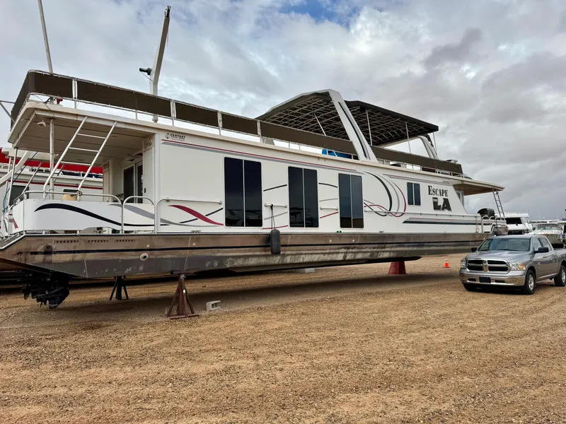 Slide: The Image of Houseboat "Escape From LA" by Fantasy, 2000 model, on dry land with truck nearby. - 24