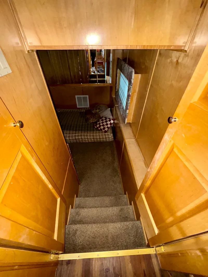 Slide: The Image of Narrow wooden staircase leading to cozy bedroom in Fantasy Escape From LA RV, 2000 model. - 6