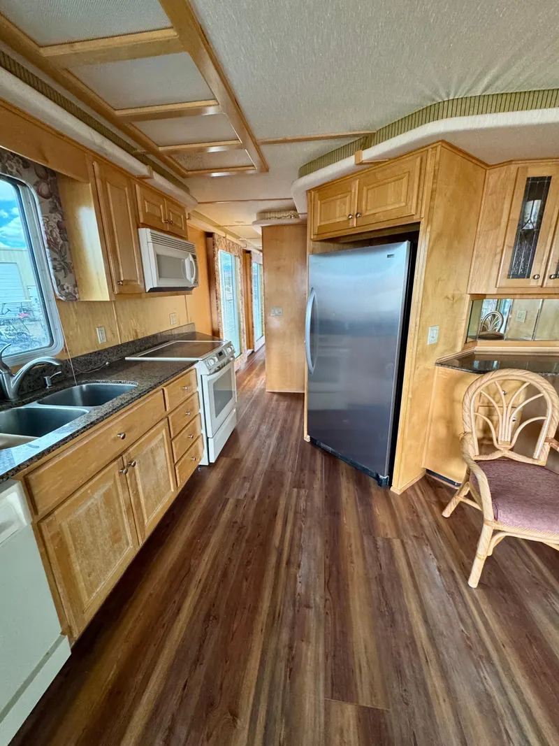 Slide: The Image of Spacious kitchen in a 2000 Fantasy Escape From LA RV with wood flooring and modern appliances. - 8