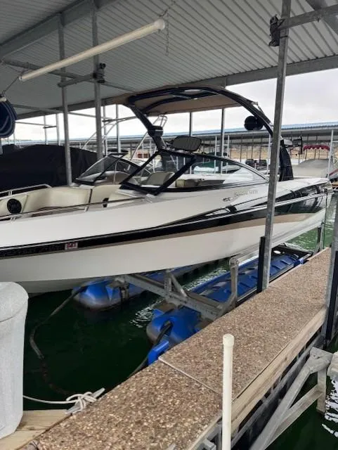Slide: The Image of 2005 Malibu Sunsetter 23 XTi boat docked under a covered marina. - 0