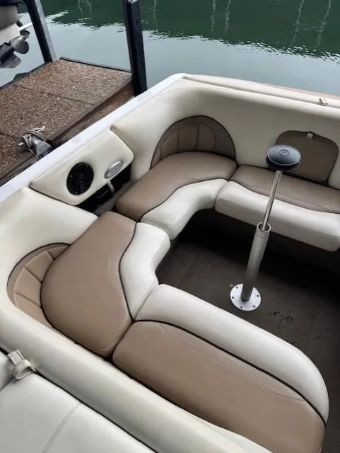 Slide: The Image of 2005 Malibu Sunsetter 23 XTi boat interior with beige and white seating near water. - 10