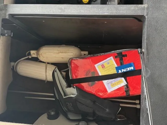 Slide: The Image of Storage compartment of a 2005 Malibu Sunsetter 23 XTi with life jacket and boat fenders. - 16