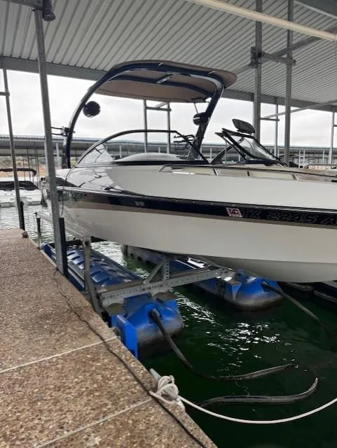 Slide: The Image of 2005 Malibu Sunsetter 23 XTi boat docked on a lift in a marina. - 18