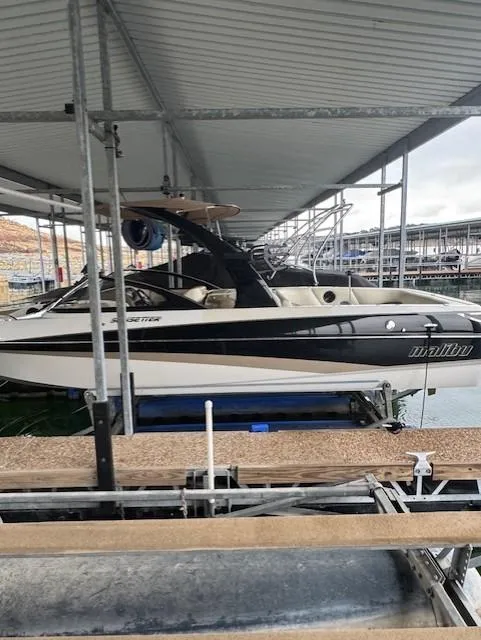 Slide: The Image of 2005 Malibu Sunsetter 23 XTi boat docked under a covered marina. - 20