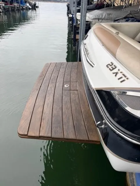 Slide: The Image of 2005 Malibu Sunsetter 23 XTi boat with wooden swim platform at dock. - 23