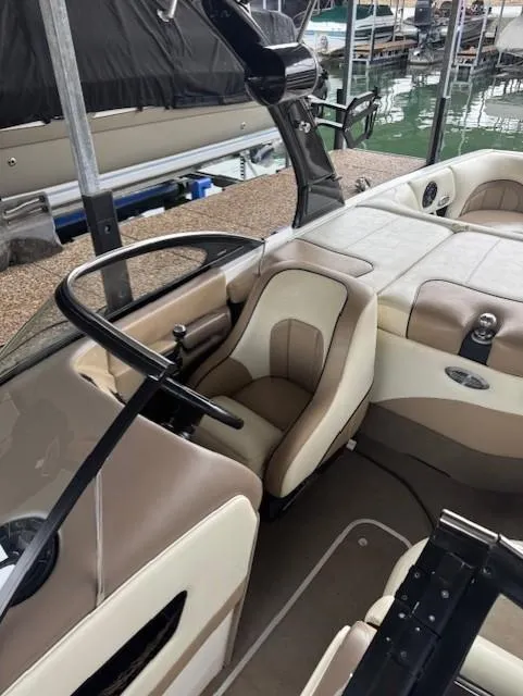 Slide: The Image of 2005 Malibu Sunsetter 23 XTi boat interior with beige seating and steering wheel. - 4