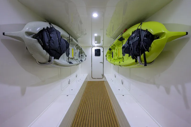 Slide: The Image of Interior storage of 2026 Grand Banks GB 85 yacht with kayaks and wooden flooring. - 20
