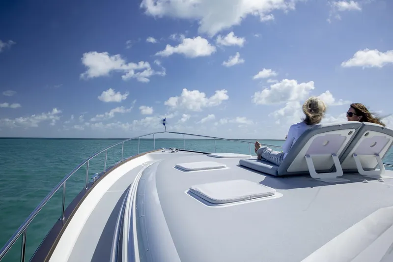 Slide: The Image of 2026 Grand Banks GB 85 yacht with people relaxing on deck under a clear sky. - 30