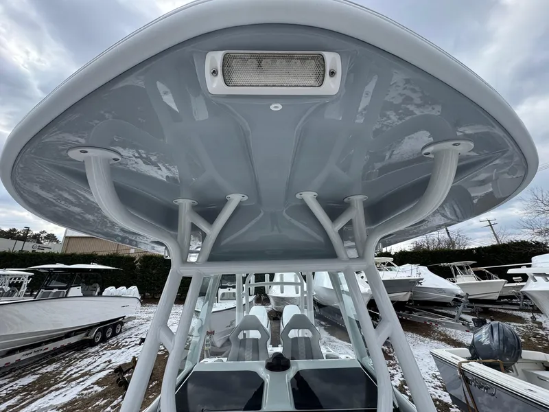 Slide: The Image of 2025 Cape Horn 28 XS boat, view of T-top and seating, in a snowy boatyard. - 25