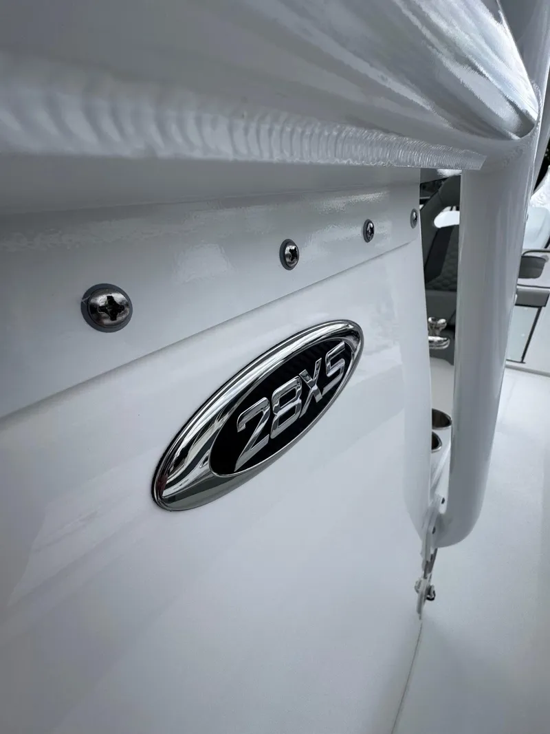 Slide: The Image of 2025 Cape Horn 28 XS boat, close-up of model emblem on white exterior. - 26