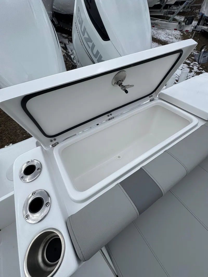 Slide: The Image of 2025 Cape Horn 28 XS boat with open storage compartment and cup holders. - 28